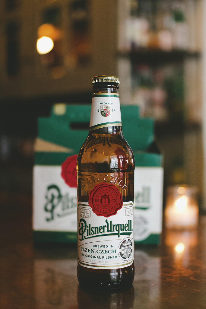 pilsner_urquell_lehdistokuva_pullo_taustalla_1000x1500